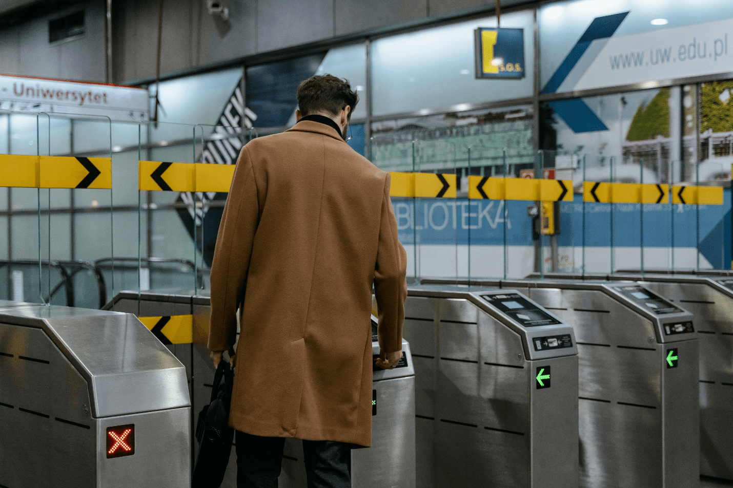 A person passing through a flap barrier turnstile