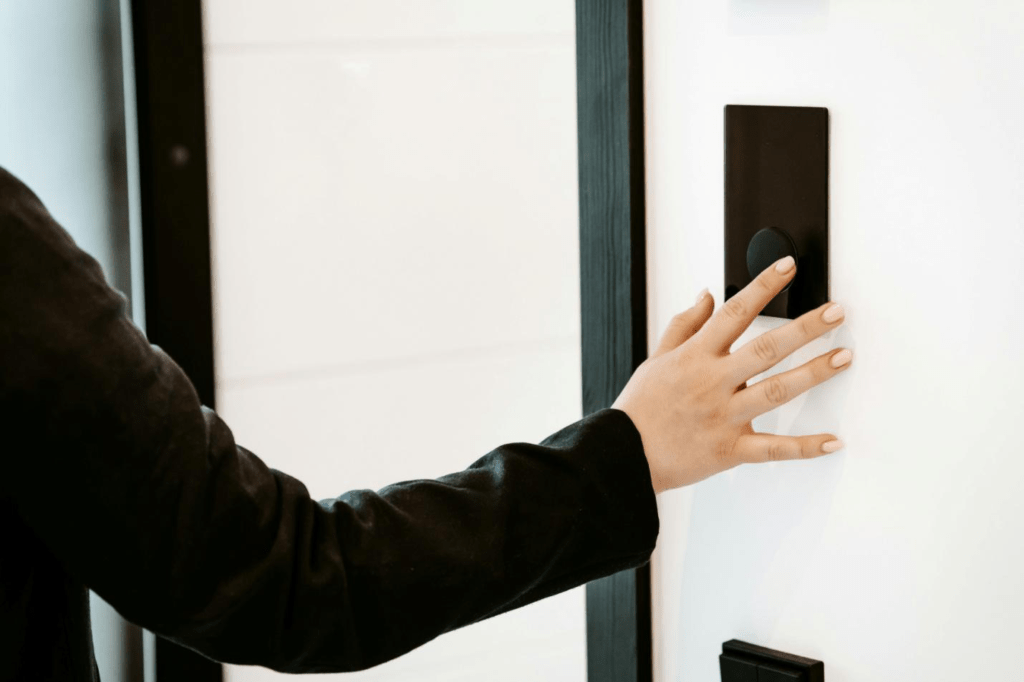 A person touching a button to open a door