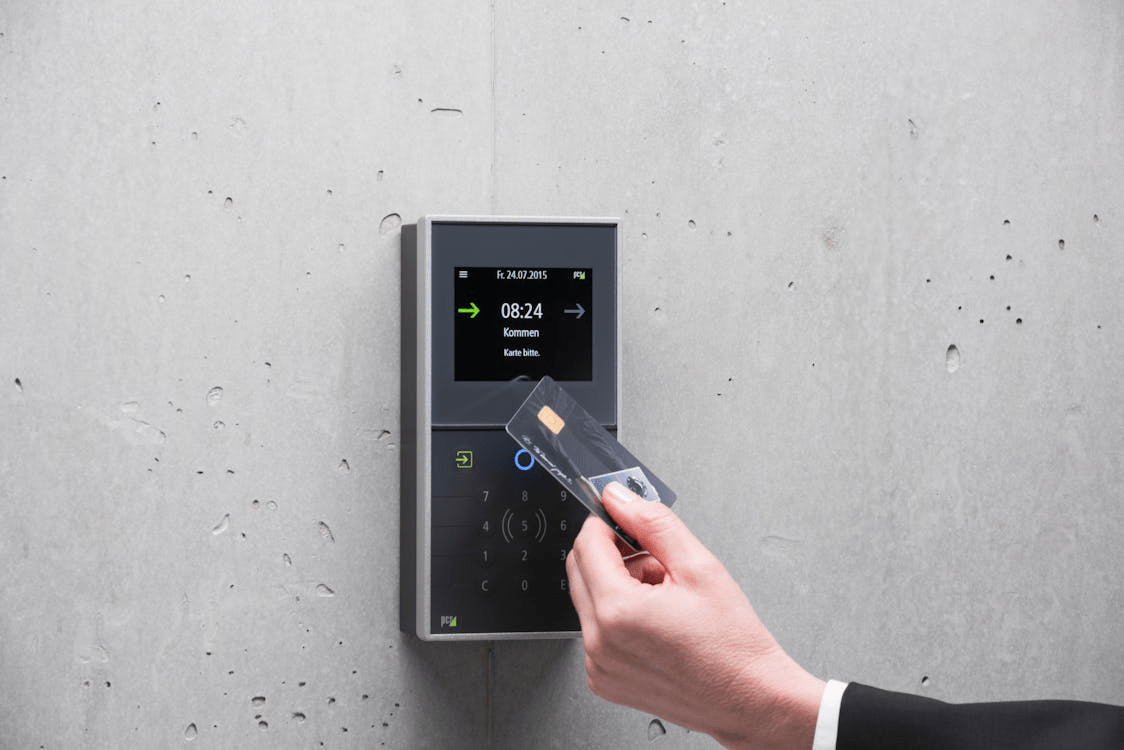 Bank employee authenticating access card on secure building access control system to enter restricted vault area